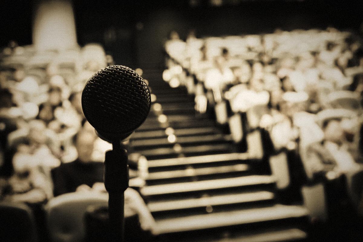 A studio microphone in front of an auditorium